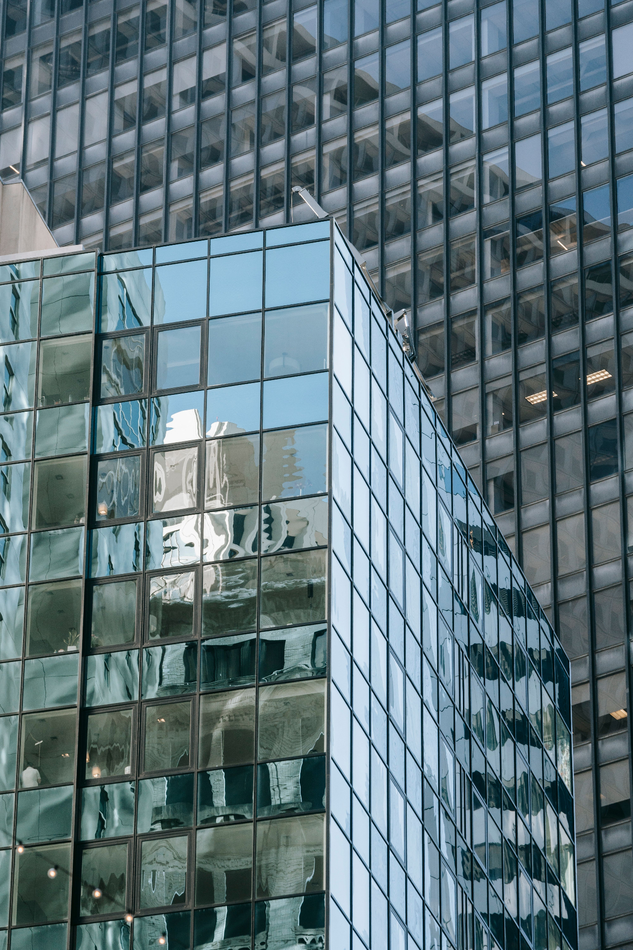 Modern glass curtainwall reflecting surrounding high-rise architecture